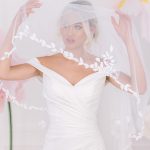 The fitted bodice of Misha crepe fitted wedding dress with a veil