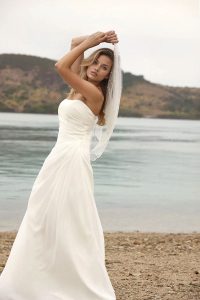 Serenity flowy chiffon beach wedding dress photographed by the water at Hamilton Island