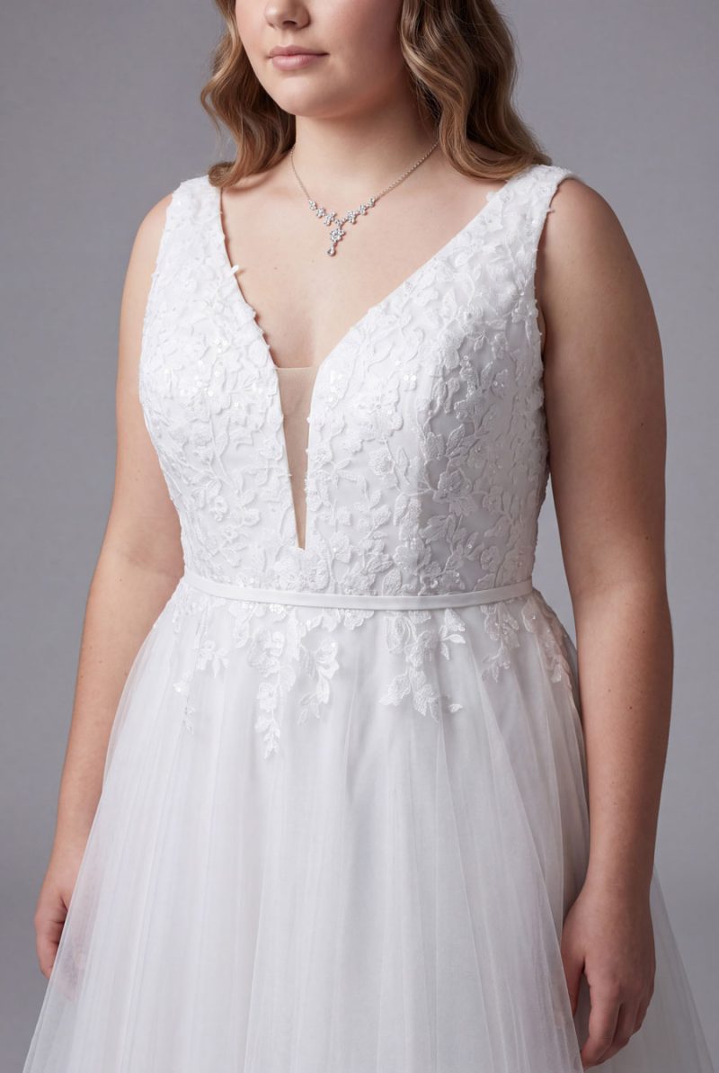 Close-up of the floral lace bodice, wide straps and illusion V-neckline on the plus size deb dress